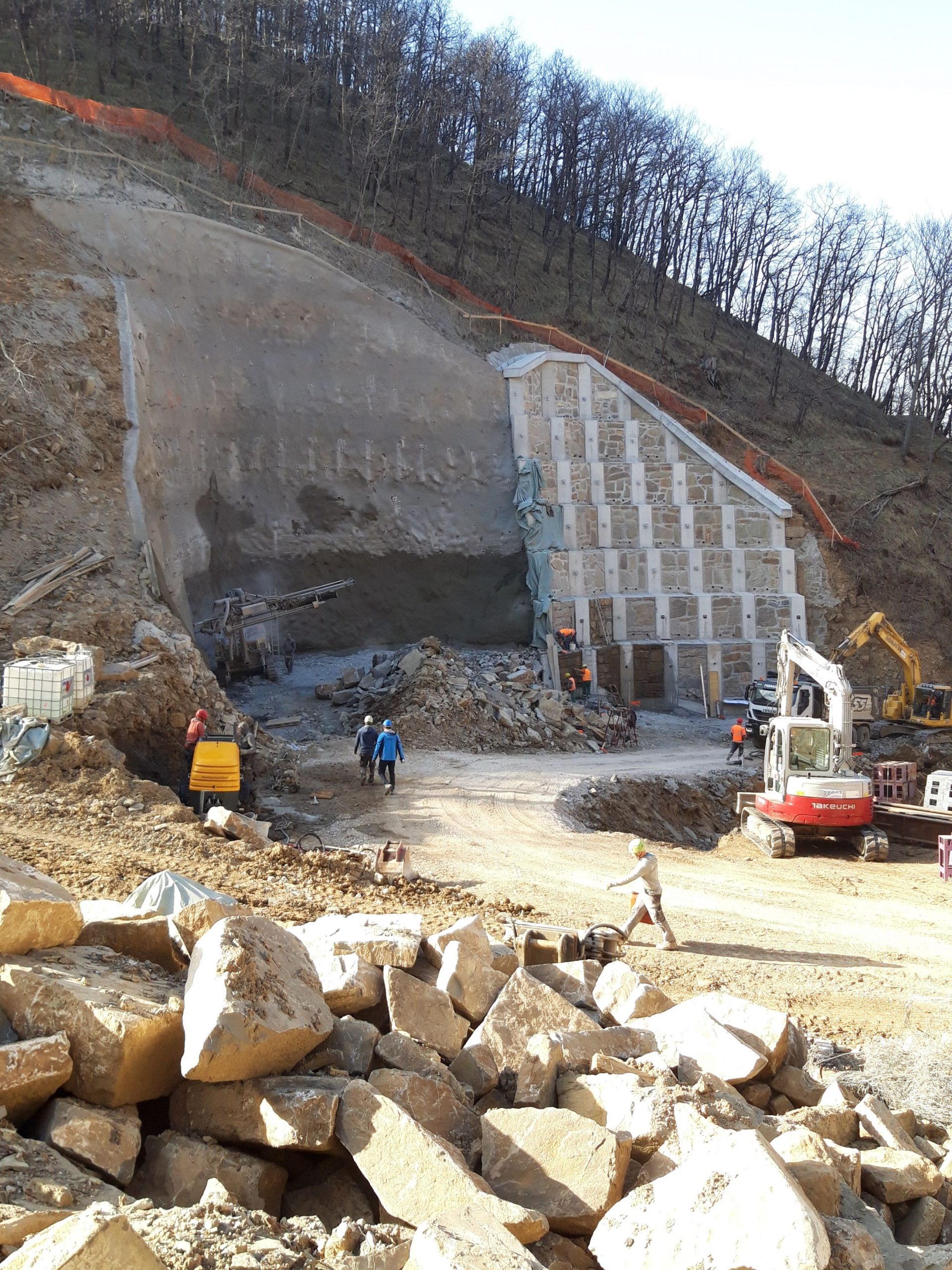 Garnol heavy machinery and workers at a mountain construction site